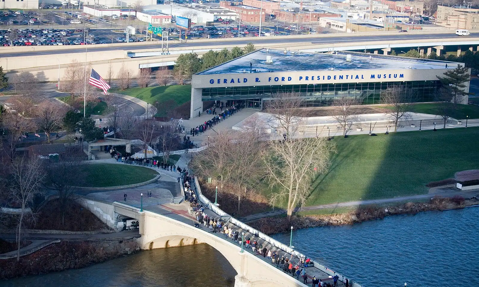 A river running past open ground with city buildings rising behind