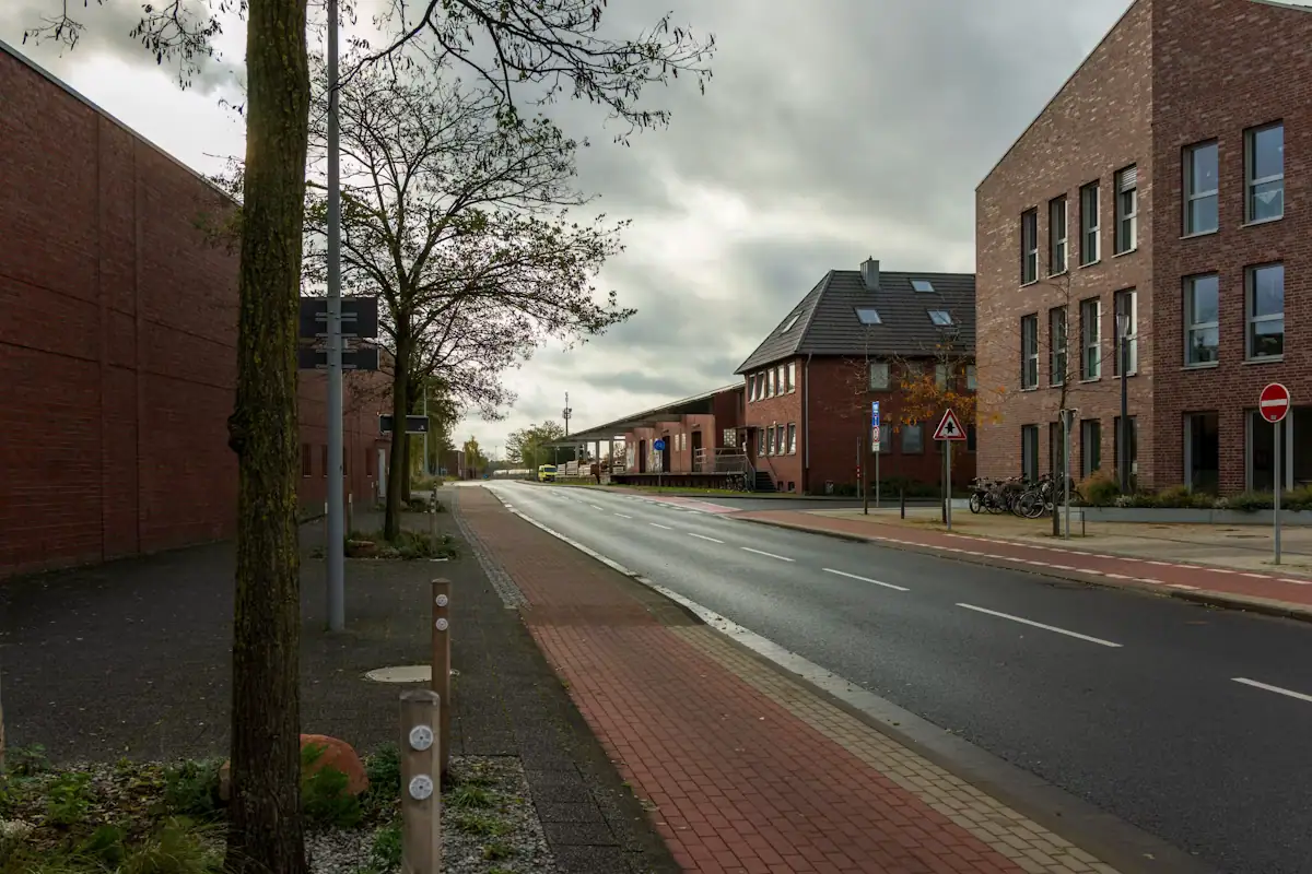 A street lined with low brick commercial buildings and street trees
