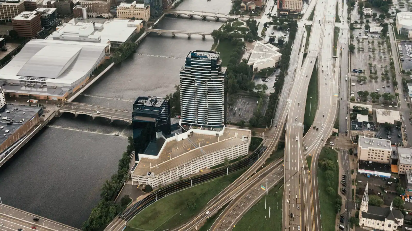 An aerial view of an expressway interchange cutting through an urban grid