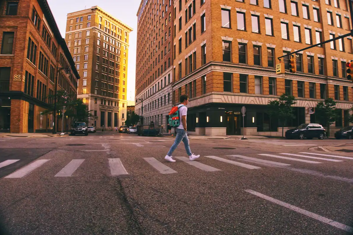 A person crossing a city street at a marked pedestrian crossing