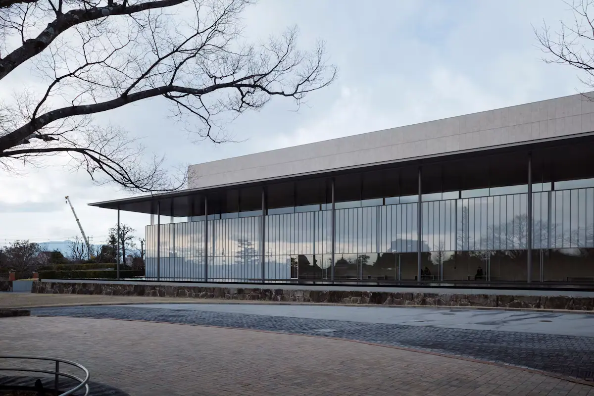 A low modern museum building with tall glass walls and a flat overhanging roof