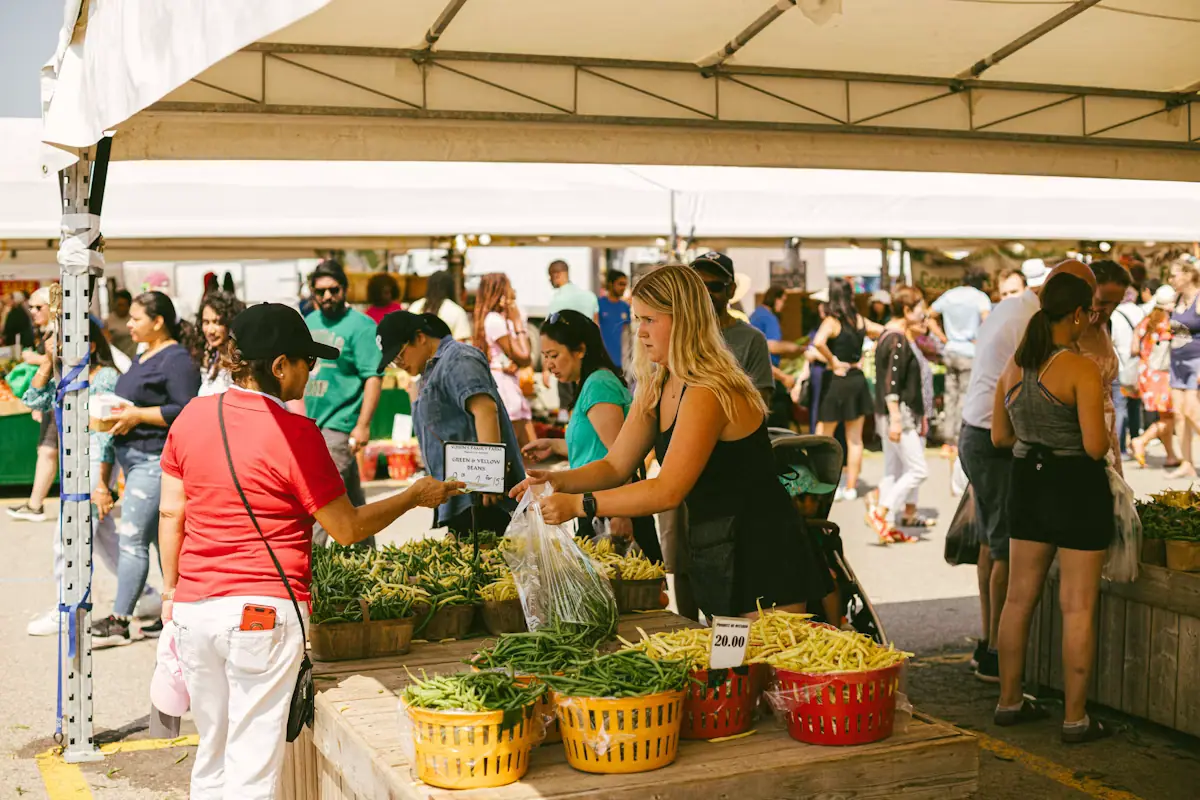 People choosing fresh vegetables at an open-air market stall