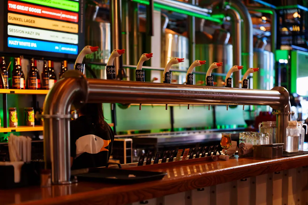 A row of beer taps and bottles behind a bar counter