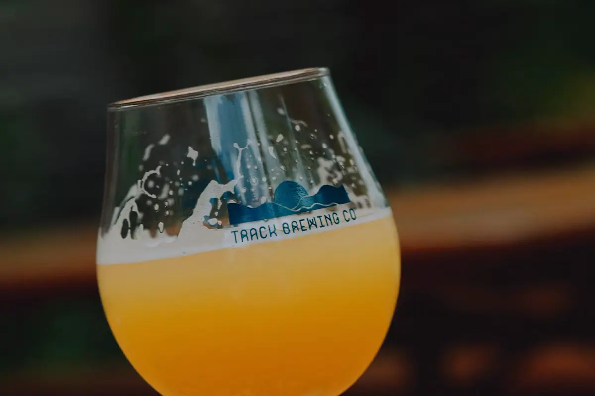 A glass of beer standing on a wooden table in a brewery taproom